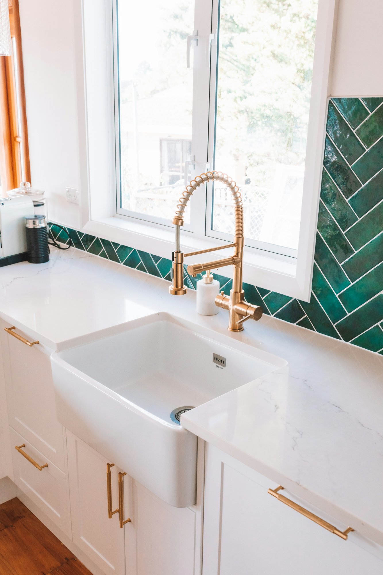 Butler sink with brass tapware and green herringbone tile
