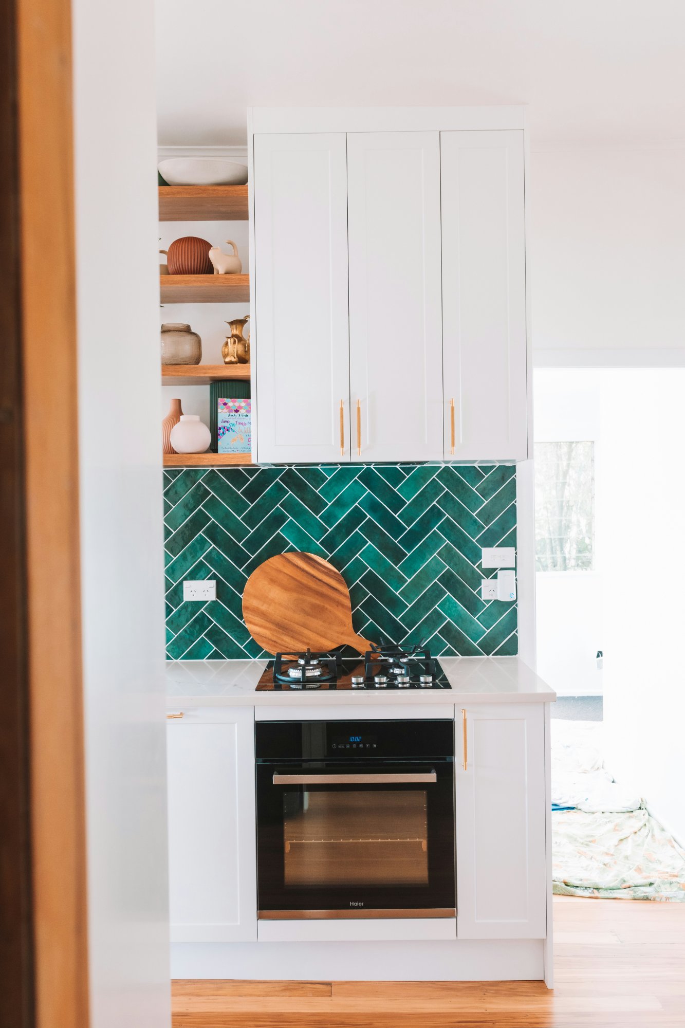 Upper cabinets and splashback — white shaker with green tile